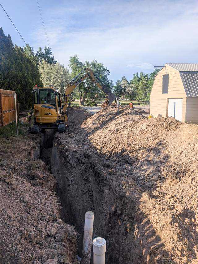 Mini excavator digging a pipe trench