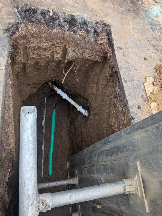 Trench with exposed line and shoring box