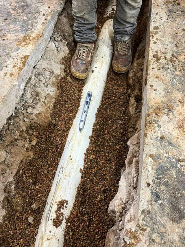 PVC pipe bedded in gravel after concrete cut